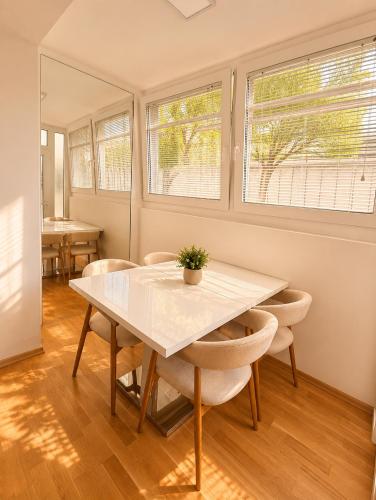 a dining room with a white table and chairs at Sealavie in Koper
