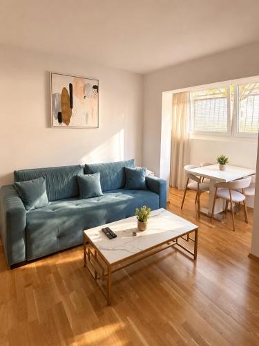 a living room with a blue couch and a table at Sealavie in Koper