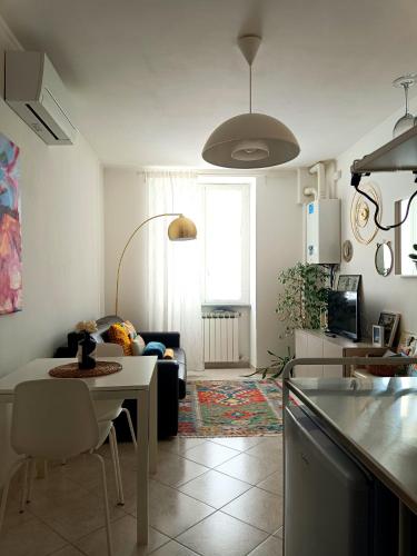 a kitchen and living room with a table and a couch at A casa di Pizz - Bilocale con parcheggio privato in Savona
