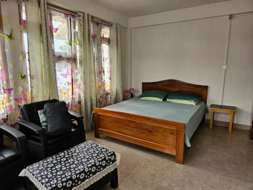 a bedroom with a bed and a chair at Salena Homestay in Cherrapunji