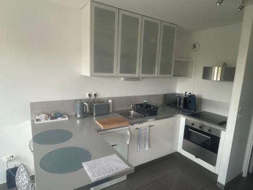 a kitchen with white cabinets and a counter top at Charmant studio vue dégagée à 300m de la plage in Dunkerque