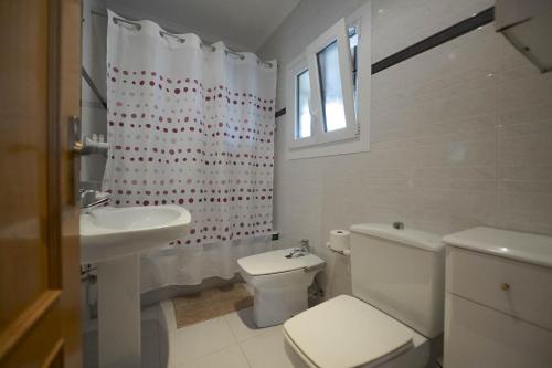 a white bathroom with a toilet and a sink at Casa Familiar Etxabe-Enea in Lasarte