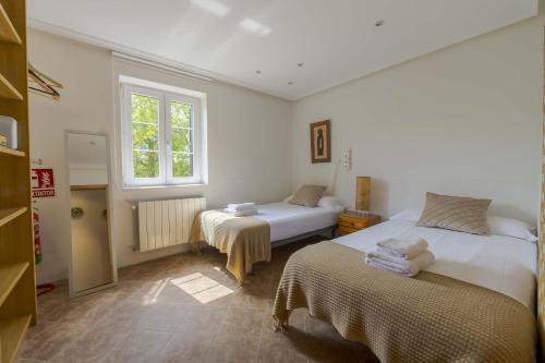 a bedroom with two beds and a window at Casa Familiar Etxabe-Enea in Lasarte