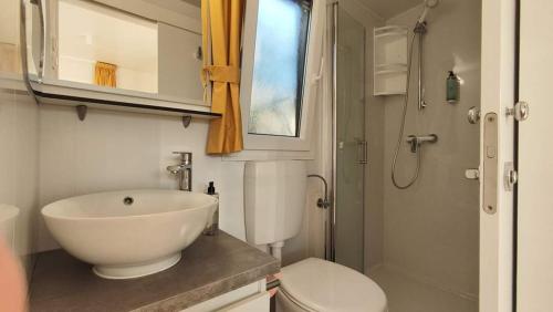 a bathroom with a white sink and a toilet at Izzi Mobile Home - Terra Park SpiritoS in Kolan