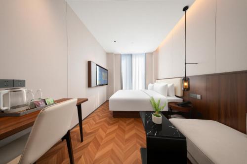 a hotel room with a bed and a desk and a kitchen at 上海安鉌蓓斯特酒店国家会展中心虹桥机场店 in Hongqiao Intl