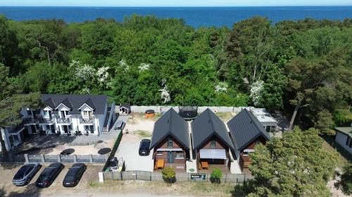 an aerial view of a house with cars parked in front at Domki na wydmie in Dziwnówek