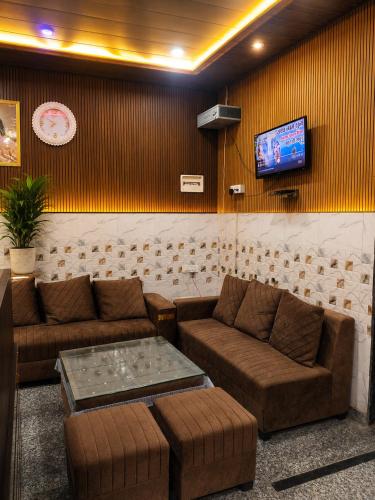 a living room with couches and a tv at Bhagwan krishan kutir in Govardhan