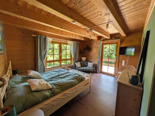 a bedroom with a bed in a log cabin at FeWo Aus'm Garten im Holzblockhaus nähe Aachen in Eschweiler