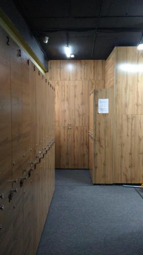 a large room with wooden walls and lockers at Kochevnik capsule Hostel in Almaty