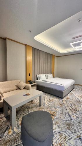 a hotel room with a bed and a couch at Grand Afrosiyob Hotel in Tashkent