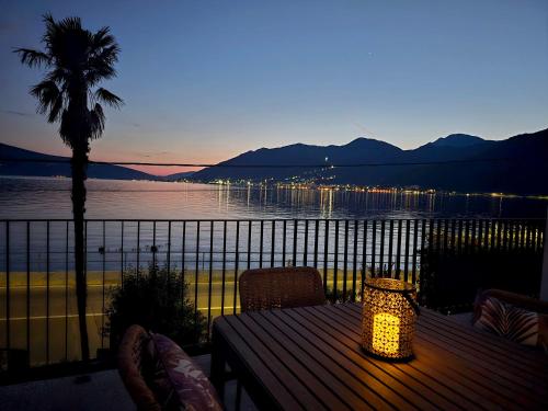 a table on a balcony with a view of the water at Apartmani Nikolić "Na pjeni od mora" in Tivat