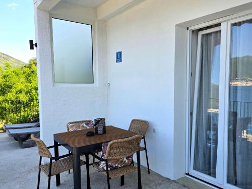 a table and chairs on a patio with a window at Apartmani Nikolić "Na pjeni od mora" in Tivat