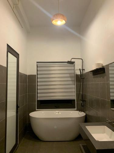 a bathroom with a bath tub and a window at Homestay Hùng Phát Pù Luông in Làng Chiêu