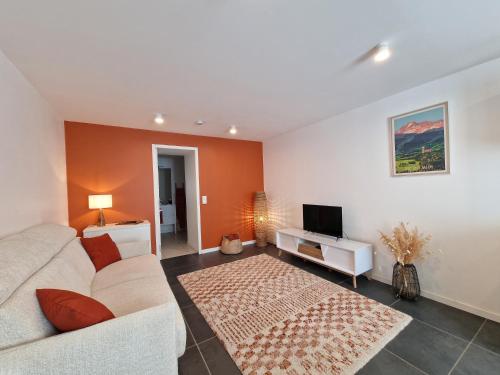 a living room with a couch and a tv at La Barroude in Bagnères-de-Bigorre