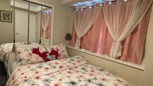 a bedroom with a bed and a mirror and pink curtains at Love Capilano in North Vancouver