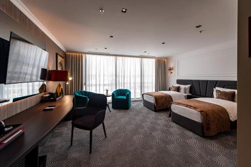 a hotel room with two beds and a desk at Sky Airport Hotel in Cluj-Napoca