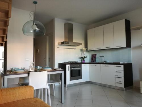 een keuken met witte kasten en een fornuis met oven bij Casa Letizia in Porto Pino