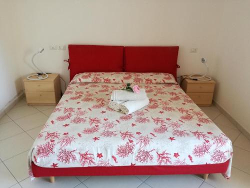 Schlafzimmer mit einem roten Bett mit einem roten Kopfteil in der Unterkunft Casa Letizia in Porto Pino