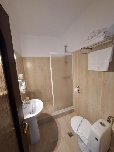 ein Badezimmer mit Toilette und Waschbecken in der Unterkunft Hotel Insula in Neptun