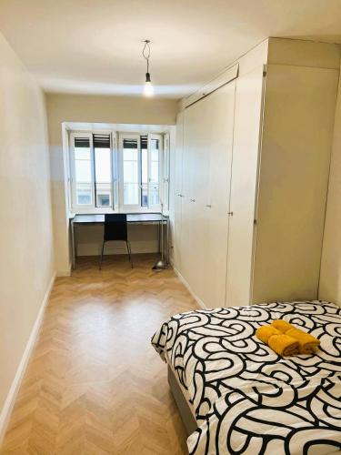 a bedroom with a bed and a desk and a window at 3 Room Old Town Flat - Munster in Zurich