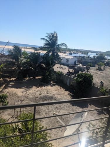 a view of a beach with palm trees and surfboards at Appartement VIDA 1 in Mahajanga