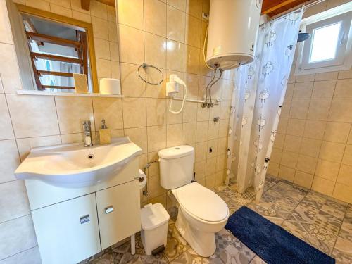 a bathroom with a white toilet and a sink at Seafront blue in Áyios Spirídhon