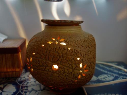 a brown vase with flowers on it sitting on a table at Ocean Sky B&B in Huxi