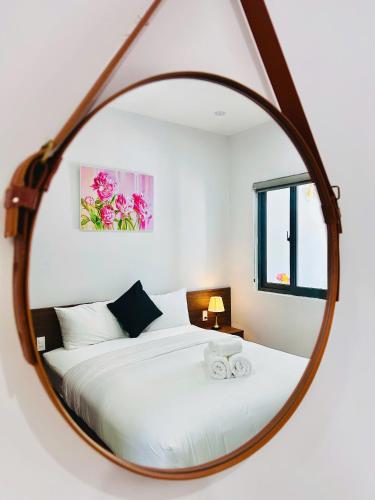 a bedroom with a bed with a round mirror at weolhouse in Hue