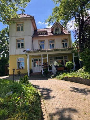 a large yellow house with a brick driveway at Castrum Visum Wernigerode in Wernigerode