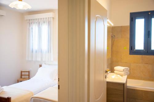 a bedroom with a bed and a sink and a tub at Yasmin House in Perdika