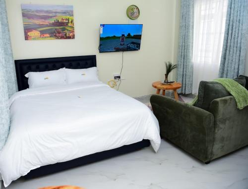 a bedroom with a large bed and a couch at comfystdngong in Nairobi