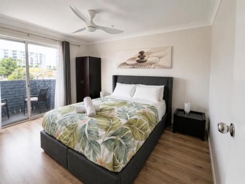 a bedroom with a large bed with a ceiling fan at West Beach Lagoon 123 - Location & Views!!! in Perth