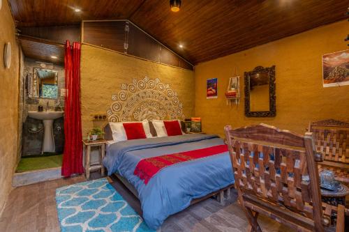 a bedroom with a large bed and a bathroom at Monkey Mud House and Glamps, Bir in Bīr
