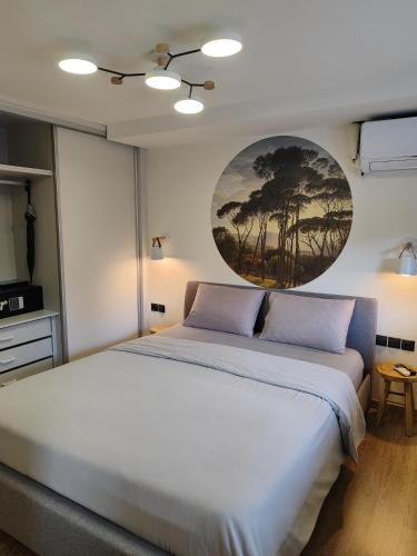 a bedroom with a white bed and a painting on the wall at Nest suite by Oikies Rentals in Neoi Epivates