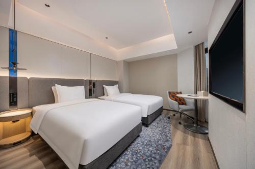 a hotel room with two beds and a flat screen tv at Holiday Inn Express Guiyang Downtown by IHG in Guiyang