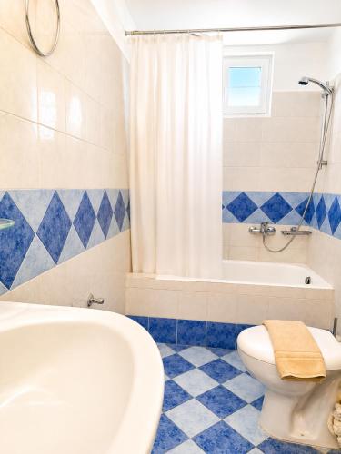 a bathroom with a tub and a toilet and a sink at Ostria Beach House in Órmos Marathokámpou