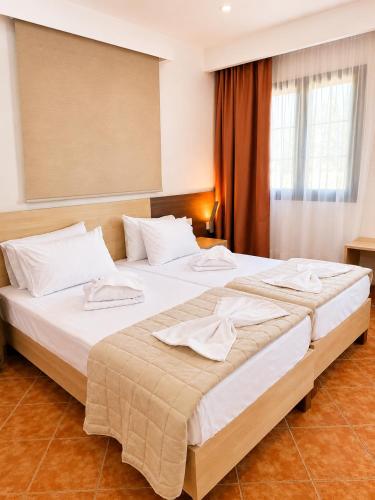 a hotel room with two beds with towels on them at Ostria Beach House in Órmos Marathokámpou