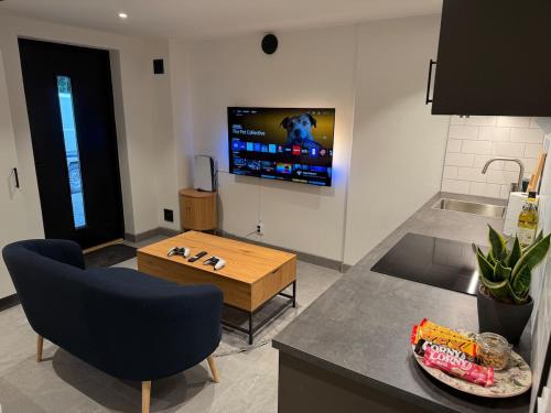 a kitchen with a table and a tv on the wall at Cozy Modern Basement in Rättvik in Rättvik