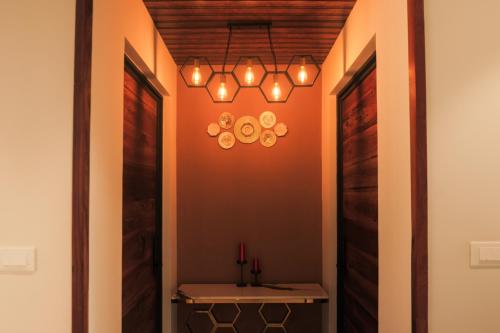 a hallway with a table and a chandelier at Kayn by spynora in Vythiri