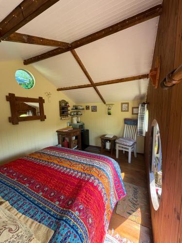 a bedroom with a bed and a chair in a room at Tyluna Cornish Glamping Cabin in Praze an Beeble