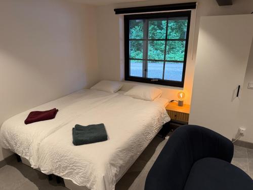 a bedroom with a bed and a window and a chair at Cozy Modern Basement in Rättvik in Rättvik
