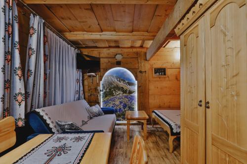 a living room with a couch and a table at Góralski Domek Waluś Zakopane - ŚCISŁE CENTRUM - Jedyny domek na Krupówkach in Zakopane