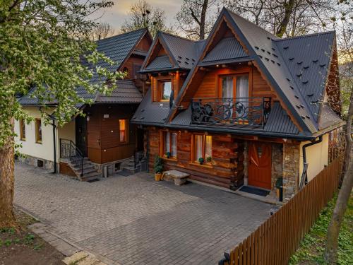 a wooden house with a fence in front of it at Góralski Domek Waluś Zakopane - ŚCISŁE CENTRUM - Jedyny domek na Krupówkach in Zakopane