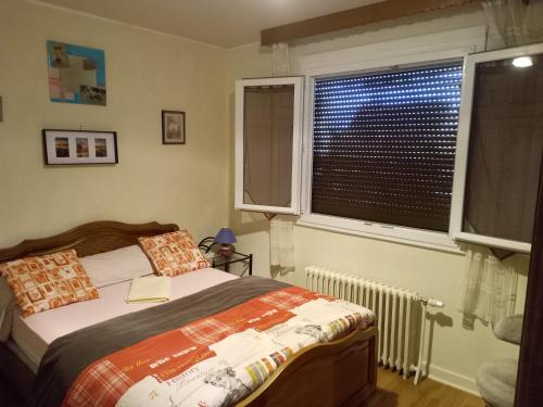 a bedroom with a bed and a window at Maison entière Garage et parking in Montluçon