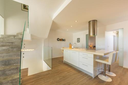 a kitchen with white cabinets and a glass wall at Caracolas Luxury House in Tarifa