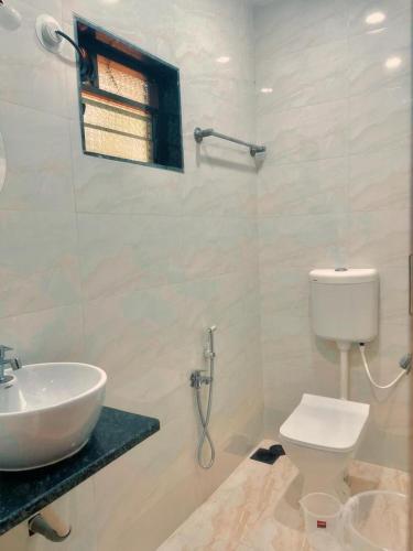a white bathroom with a sink and a toilet at Silver Shark Boutique Villas in Ajgaon