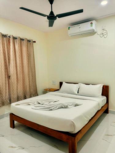 a bedroom with a large bed with a ceiling fan at Silver Shark Boutique Villas in Ajgaon