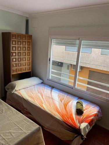 a bedroom with a window and a bed with a blanket on it at GERMANIES HOME y Garaje , Algemesí Home in Algemesí
