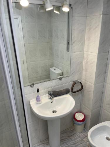 a bathroom with a sink and a mirror and a toilet at GERMANIES HOME y Garaje , Algemesí Home in Algemesí