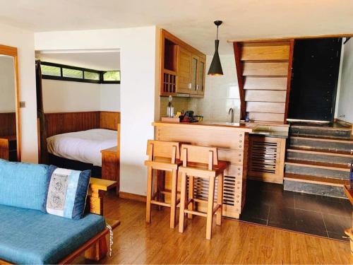 a room with a kitchen and a bed and a couch at Sapa mến khách sapa jade hill in Lao Cai